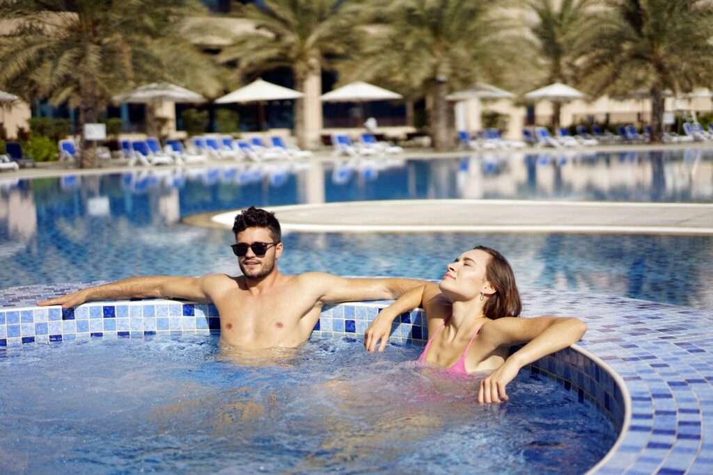 An outdoor Jacuzzi surrounded by lush greenery, offering a relaxing oasis for guests at the Al Bahar Hotel and Resort