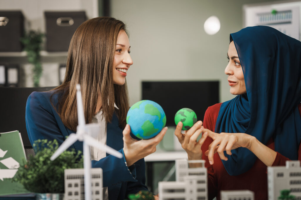 Diverse team, middle-aged Asian businessman, Caucasian young businesswoman, Muslim hijab-wearing