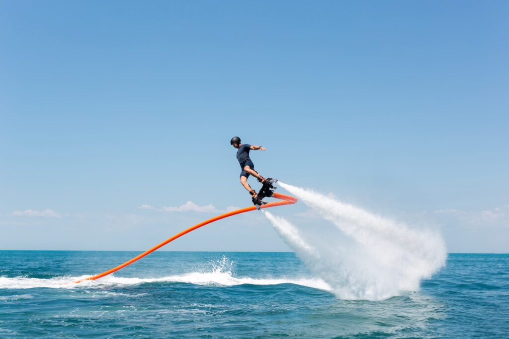 Water extreme sport. The guy is flying at the aquatic flyboard. A lot of water pressure